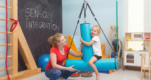 Duyu bütünleme salıncağı ile terapi seansında çocuk ve terapist