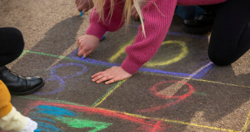 Çocuk renkli numaralı seksek karelerinde tek ayakla sekerken