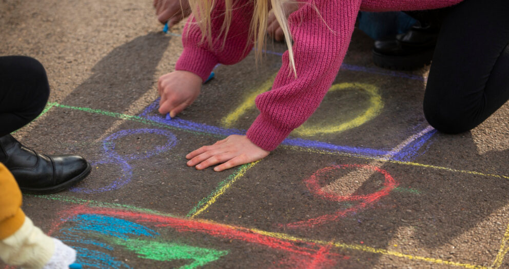 Çocuk renkli numaralı seksek karelerinde tek ayakla sekerken